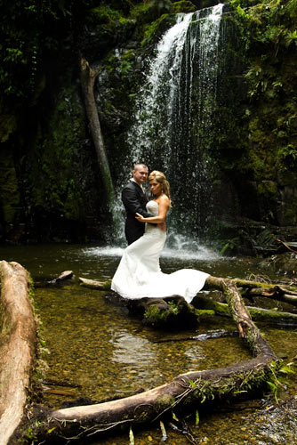 River wedding photo featuring bridal couple and waterfall. Wedding Photography Melbourne waterfall and bridal couple.